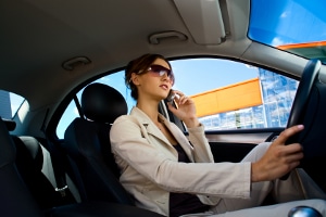 Fahrlässige Körperverletzung: Beim Autofahren sollte der Blick lieber auf den Verkehr gerichtet sein.